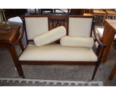 An Edwardian mahogany framed sofa with cream upholstery and bolster cushions