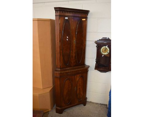 A reproduction mahogany veneered corner drinks cabinet