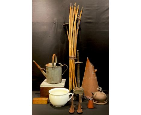 A galvanised watering can; a copper conical coal scuttle; a brass fire iron; child's shoe lasts; a copper lamp base; a brass 