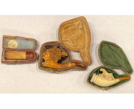 A Meerschaum pipe, as a lady in bonnet; a Meerschaum cigar holder; another; all cased (3) 
