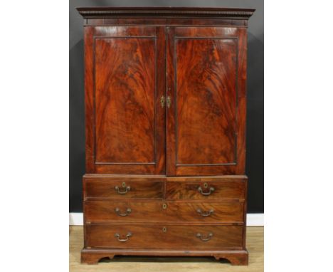 A George III mahogany linen press, dentil cornice above a pair of panel doors enclosing four sliding trays, the base with two