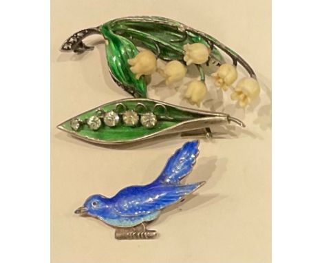 A silver and enamel lily of the valley brooch, Birmingham 1918; another, marked Sterling; an enamel bluebird brooch (3) 