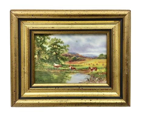 Framed porcelain plaque, hand painted with cows drinking from a lake in a countryside landscape, by Francis Clark, formerly a