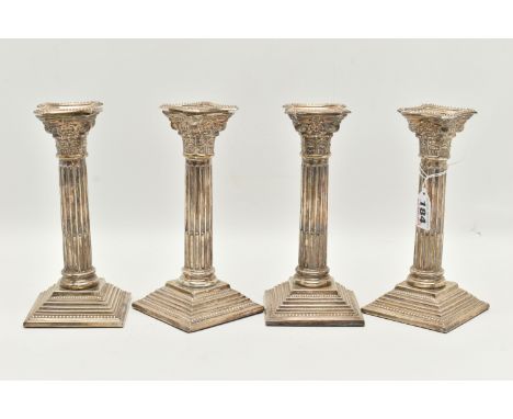 A SET OF FOUR SILVER CANDLESTICKS, Corinthian pillar candle sticks on weighted square bases, each hallmarked 'W A Humphries L