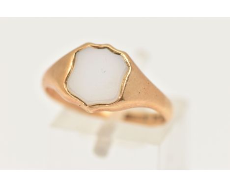 A YELLOW METAL SIGNET RING, set with a polished white chalcedony shield shape inlay, to a polished band, stamped 18ct, ring s