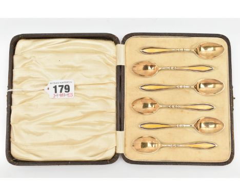 A CASED SET OF SIX EARLY 20TH CENTURY SILVER GILT AND ENAMEL TEAPSOONS, each spoon decorated with a yellow guilloche enamel h
