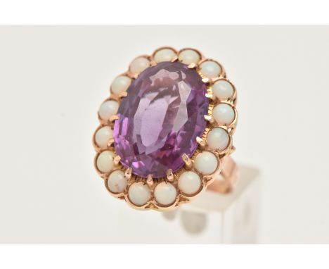 A ROSE METAL LARGE CLUSTER RING, set with a central oval cut synthetic sapphire, claw set in a surround of circular cut opal 