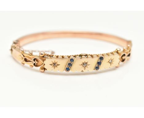 A 9CT GOLD HINGED BANGLE, displaying three star set rose cut diamonds, two rows of three circular cut blue sapphires, applied