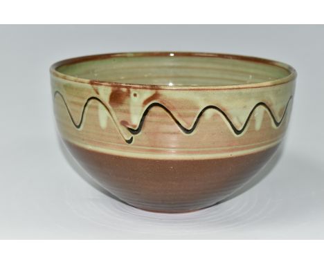 RAY FINCH (1914-2012) FOR WINCHCOMBE POTTERY: A GREEN AND BROWN GLAZED BOWL, with a slip trailed band, on a red clay body, im