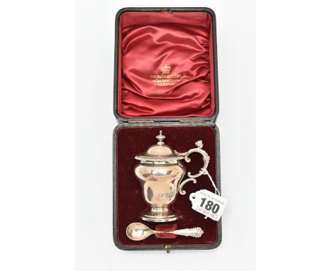 A CASED LATE VICTORIAN SILVER MUSTARD WITH SPOON, urn shape mustard fitted with a scrolling handle and figural head, hinged c