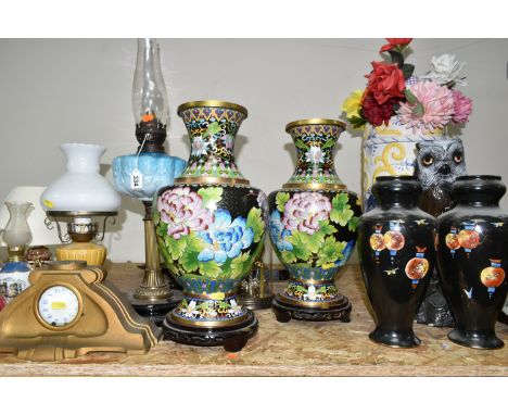 A GROUP OF OIL LAMPS, VASES AND CLOCKS, comprising two large Cloisonné vases supported by carved wooden Oriental plinths, a V