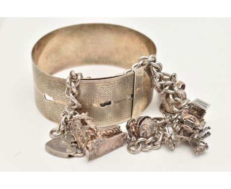 A WHITE METAL CHARM BRACELET AND BANGLE, the charm bracelet suspending eight charms from a curb link chain, together with a b