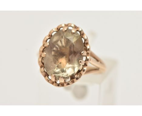 A 9CT GOLD CITRINE RING, designed as an oval cut Citrine, double four claw set within a scalloped surround, raised basket set