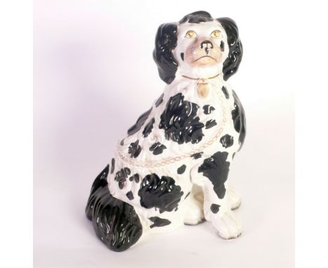 A VICTORIAN STAFFORDSHIRE POTTERY MANTEL SHELF SPANIEL  with black patches, cars and tail, with a detached front leg, 12 1/2"