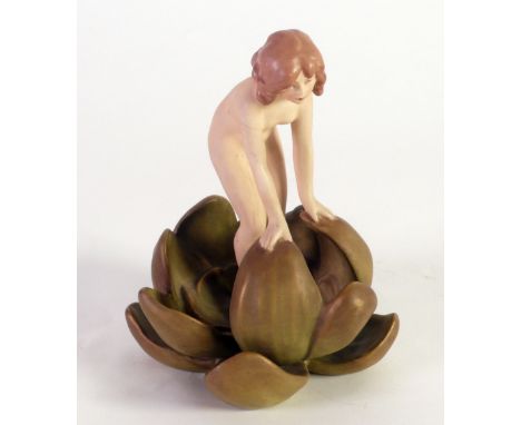 A SMALL ROYAL DUX PORCELAIN MODEL OF A NAKED YOUNG LADY emerging from a water lily, decorated in typical matt colours, 6 1/4"