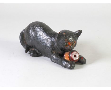 BRETBY BLACK GLAZED MODEL OF A CAT,  modelled lying down with a cotton reel, between its front paws (2230), 10" (25.4cm) long
