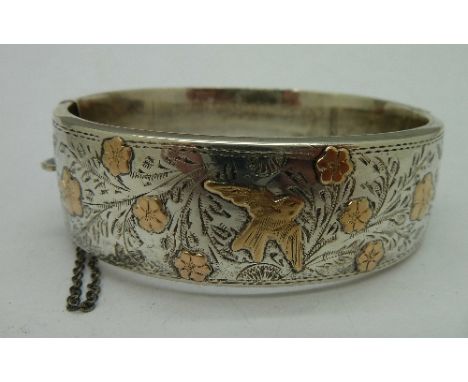 A silver bangle with gold decoration, weight 28g