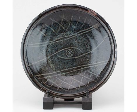 † MICHAEL CARDEW (1901-1983) for Wenford Bridge Pottery; a stoneware dish covered in iron and cobalt glaze with eye decoratio