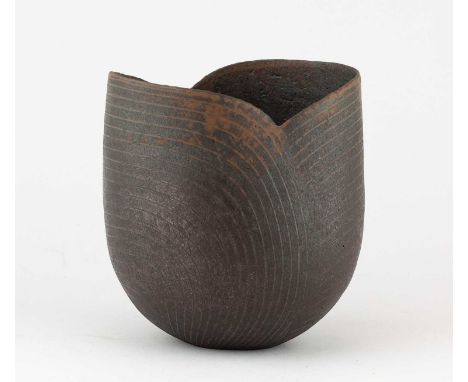 † JOHN WARD (1938-2023); an oval stoneware bronze cut rim vessel with incised linear design, impressed JW mark, height 18cm. 