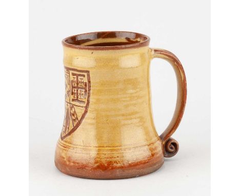 Leach Pottery; a slipware mug decorated with a heraldic shield, impressed pottery mark, height 12cm.Condition Report: Glaze r
