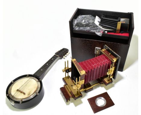 A reproduction brass mounted walnut plate camera with leather bellows, plate size 17.5 x 12.5cm, with a banjolele in fitted c