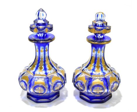 A pair of 19th century Bohemian faceted glass perfume bottles and stoppers, with relief and gilt floral decoration, height 17