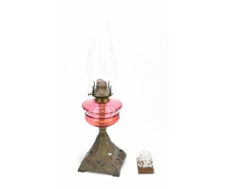 A late 19th century oil lamp with clear shade/chimney and cranberry reservoir, on foliate motif base, height approx 25cm and 