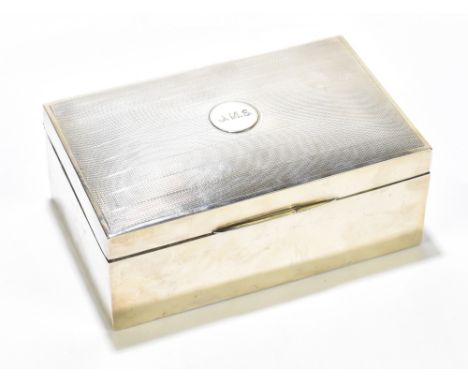 A hallmarked silver mounted cigarette box, the lid with engraved initials 'J.N.S.' and engine turned detail, marks rubbed, 17