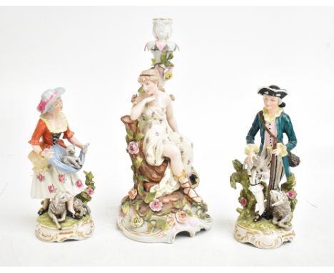 A late 19th century Continental hard paste porcelain figural candlestick representing a seated maiden in naturalistic setting