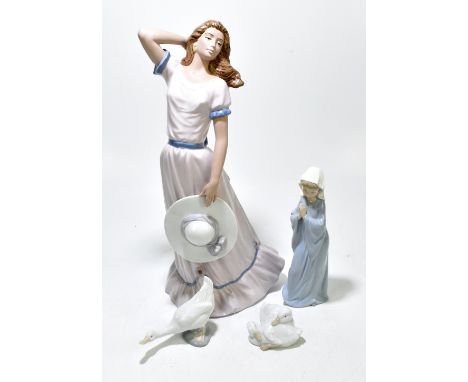 NADAL; a large figure of a maiden with her arms stretched behind her head holding a hat, height 51cm, together with thee Nao 