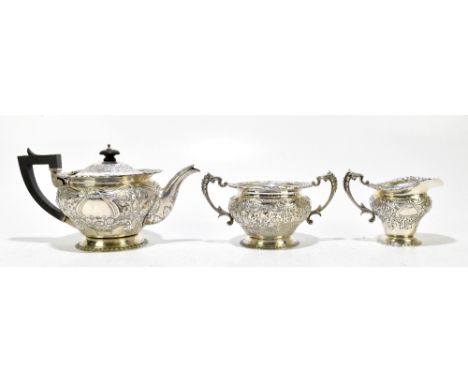 WAKELY &amp; WHEELER; a Victorian hallmarked silver three piece tea service with bright cut and repousse foliate and scroll d