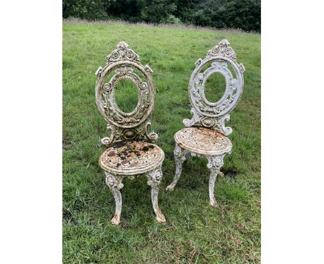A pair of Victorian-style white painted metal garden chairs of oval form, height 94.5cm.