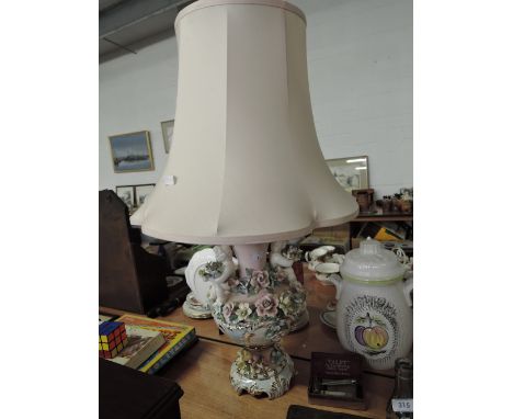 A continental style table lamp with floral and cherub decoration