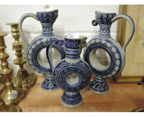 Three ceramic decanters in a Mettlach pottery style with a circular body and relief decoration