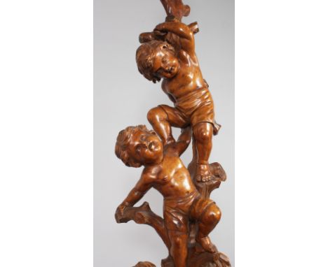 A SUPERB 18TH-19TH CENTURY ITALIAN CARVED WALNUT STANDARD LAMP with three cherubs climbing a tree, on a circular base with th