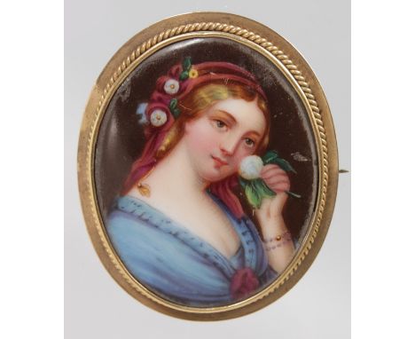 A VICTORIAN OVAL PORTRAIT BROOCH, young lady holding a rose.