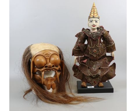 Indonesian puppet on stand together with Indonesian mask
