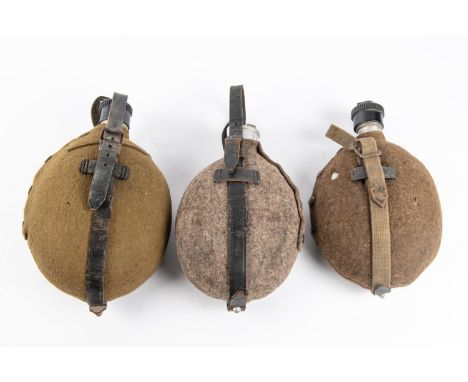 A WWII Third Reich water bottle, field grey cover, alloy cap; another  with bakelite cap; another similar. First 2 GC, the ot
