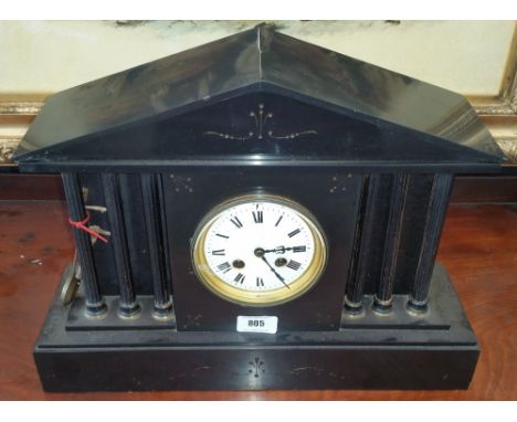 A FRENCH BLACK MARBLE MANTEL CLOCK OF SIMPLE FORM with a white enamelled face with roman numerals and brass bezel flanked by 