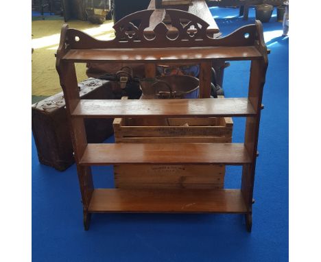 AN EARLY 20TH CENTURY WALNUT FOUR TIER HANGING SHELF with reeded edges and pierced back.