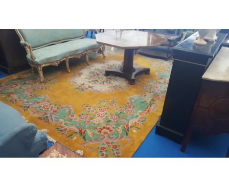 A VERY LARGE ORIENTAL CARPET on yellow ground, with a cream patterned foliate centre surrounded by roses on a green band. 12f