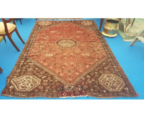 A PERSIAN BROWN & PINKY RED GROUND CARPET  with all over decoration. 9' X 6'.