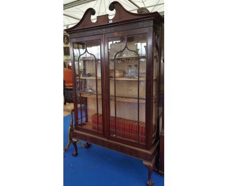 AN EARLY 19TH CENTURY MAHOGANY DISPLAY CABINET IN THE IRISH STYLE with twin glazed doors and architectural pediment.