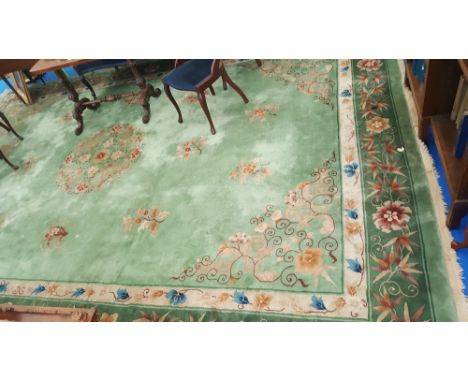 A VERY LARGE CHINESE CARPET ON LIGHT GREEN GROUND RUG, with central motifs & floral pattern border. 15ft 11ins  x 10ft 11ins"