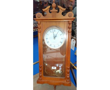 A MODERN OAK CASED WALL CLOCK with a quartz mechanism and a Westminster chime.