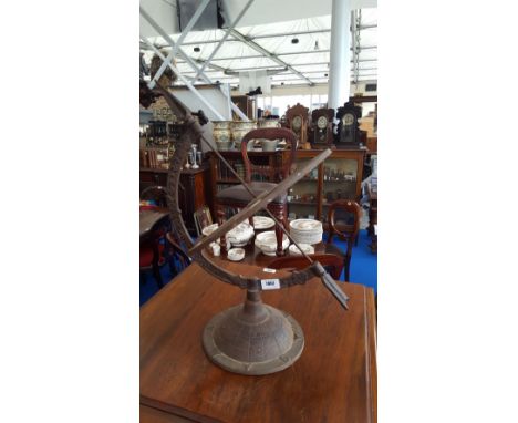A CAST IRON ARMILLARY SPHERE & A CERAMIC BASE.