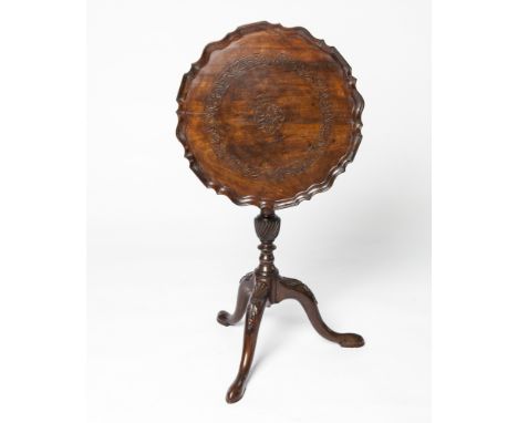 A 19TH CENTURY MAHOGANY CARVED WINE TABLE on tripod supports.