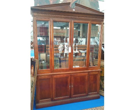 A TWO DOOR GLAZED BOOKCASE with architectural cornice.
