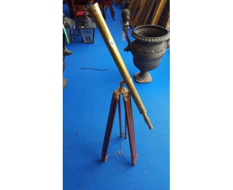 A BRASS TELESCOPE ON A TRIPOD BASE.