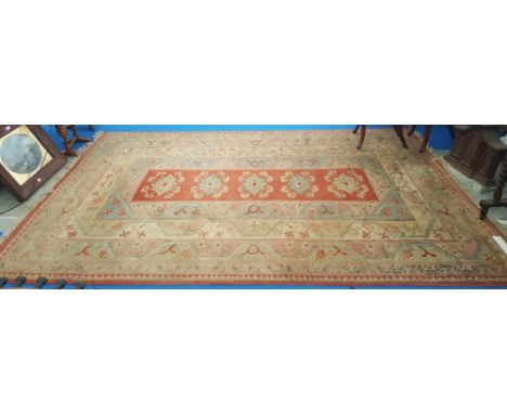 A TURKISH WOOL CARPET in pastel shades with geometric detail rust coloured field within wide geometric borders. 9ft 8ins x 6f